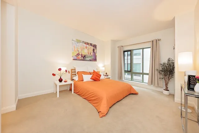 a bedroom with a bed and a large window