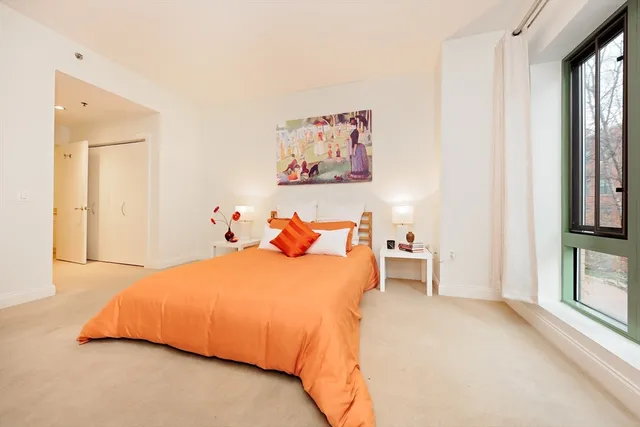 a bedroom with a bed and a large window