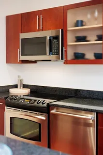 a kitchen with an oven a cabinets and a wooden floor