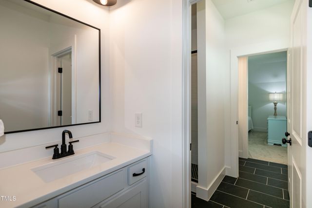 a bedroom with a large bed and a chandelier fan