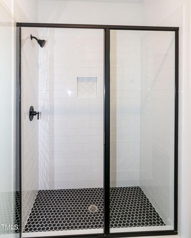 a bedroom with a bed and a flat tv screen on dresser