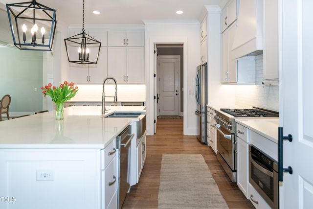 a view of a dining room with furniture a chandelier and wooden floor
