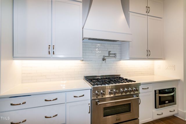 a view of a hallway with wooden floor and a living room