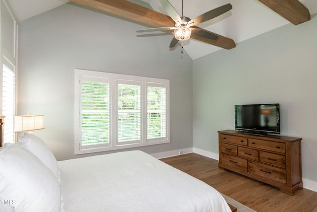 a spacious bedroom with a bed and a ceiling fan