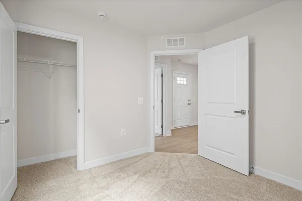 an empty room with closet and a bathroom