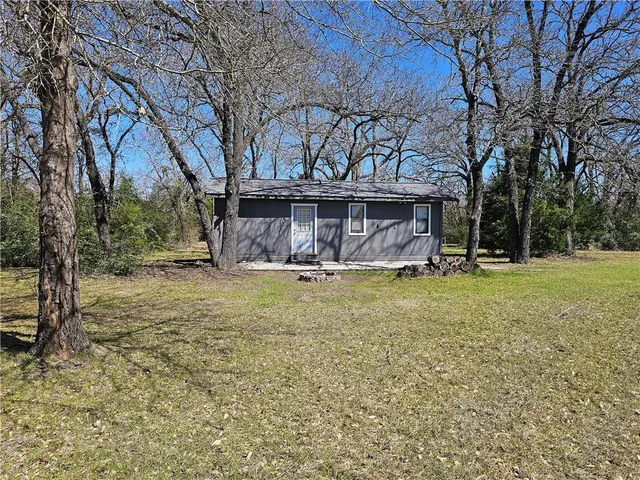 a view of a livingroom with a chandelier fan and windows