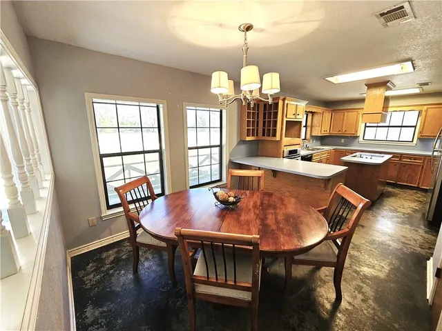 a view of a dining room with furniture a chandelier and wooden floor