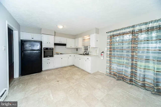 a kitchen with granite countertop a refrigerator and a sink