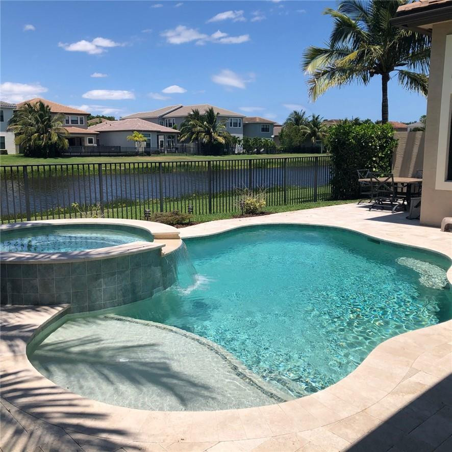 9338 Eden Roc Court Delray Beach, FL 33446 - Photo 1 of 1 a view of a swimming pool with a table and a chairs