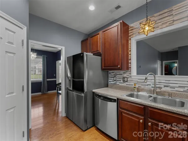 a kitchen with stainless steel appliances granite countertop a refrigerator and a sink