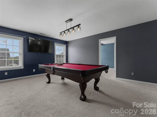 a room with pool table and windows