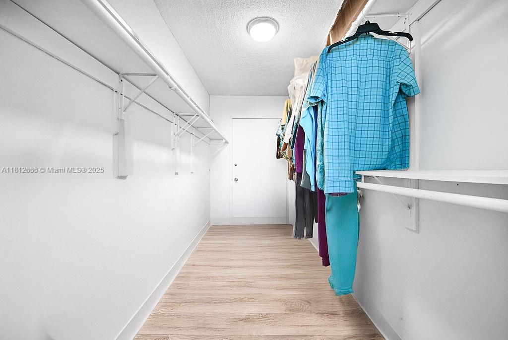 18041 Biscayne Boulevard, Unit 1201 Aventura, FL 33160 - Photo 15 of 42 Walk-in closet with custom shelving, providing excellent storage solutions for your wardrobe and accessories.