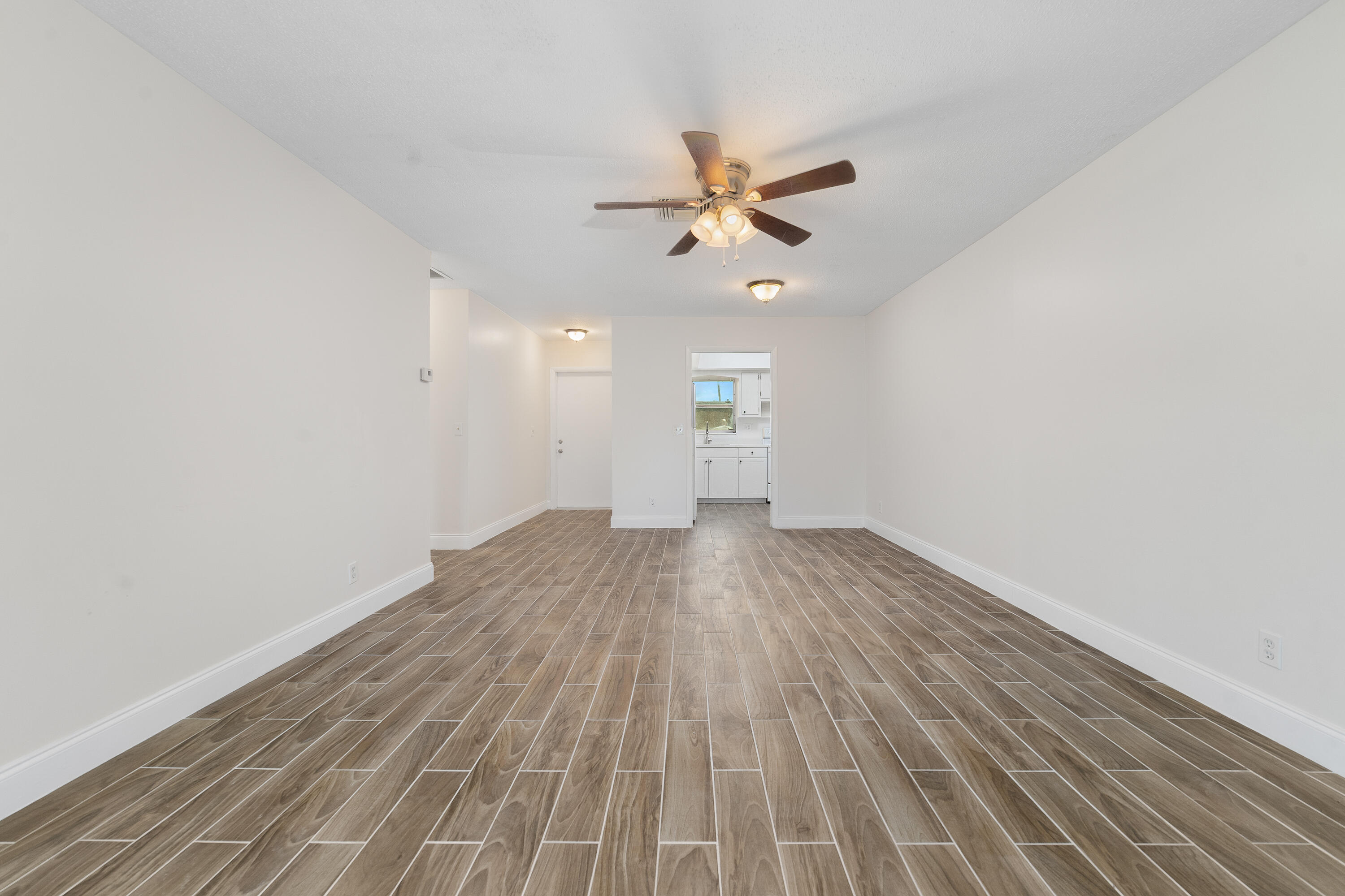 2567 Dudley Drive West, Unit F West Palm Beach, FL 33415 - Photo 11 of 41 an empty room with wooden floor fan and windows