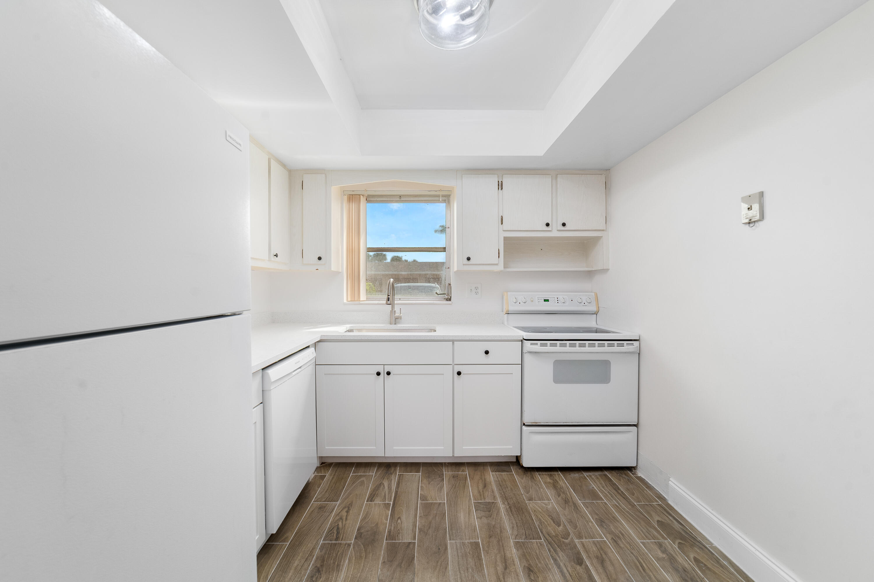 2567 Dudley Drive West, Unit F West Palm Beach, FL 33415 - Photo 12 of 41 a kitchen with a sink cabinets and a refrigerator