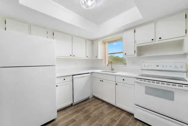 a kitchen with white cabinets and white appliances