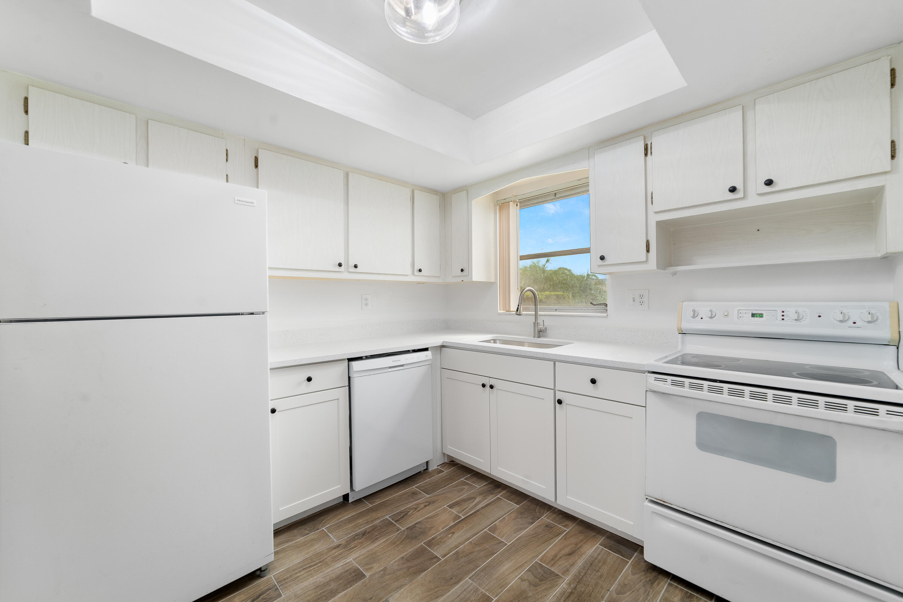 2567 Dudley Drive West, Unit F West Palm Beach, FL 33415 - Photo 13 of 41 a kitchen with granite countertop white cabinets and white appliances