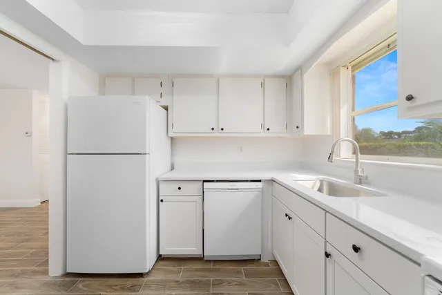 a kitchen with cabinets and a refrigerator