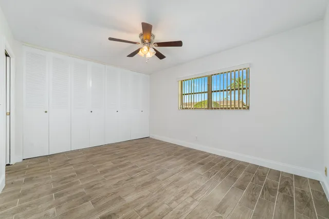 a view of a big room with wooden floor and windows