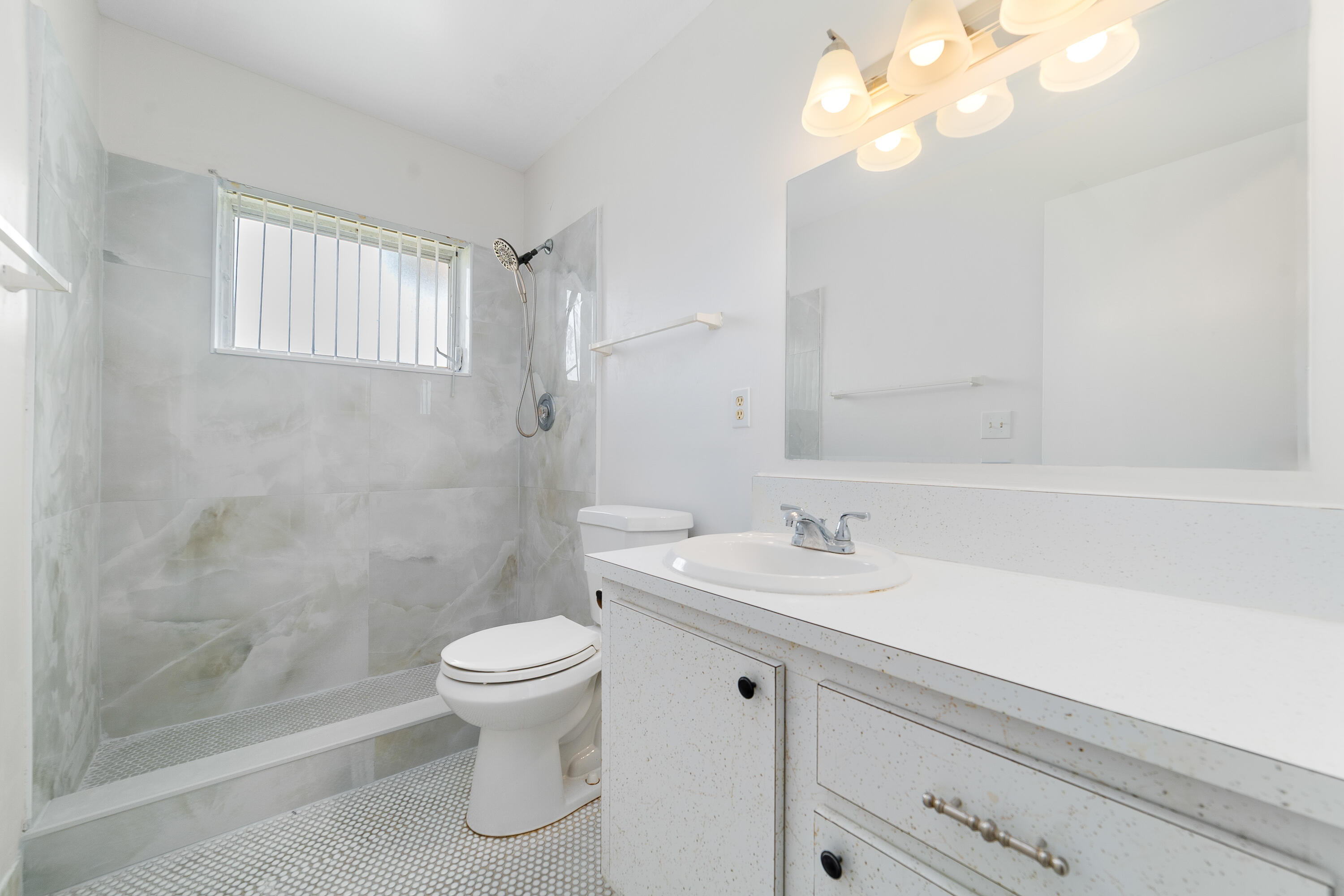 2567 Dudley Drive West, Unit F West Palm Beach, FL 33415 - Photo 22 of 41 a bathroom with a sink a toilet and a mirror