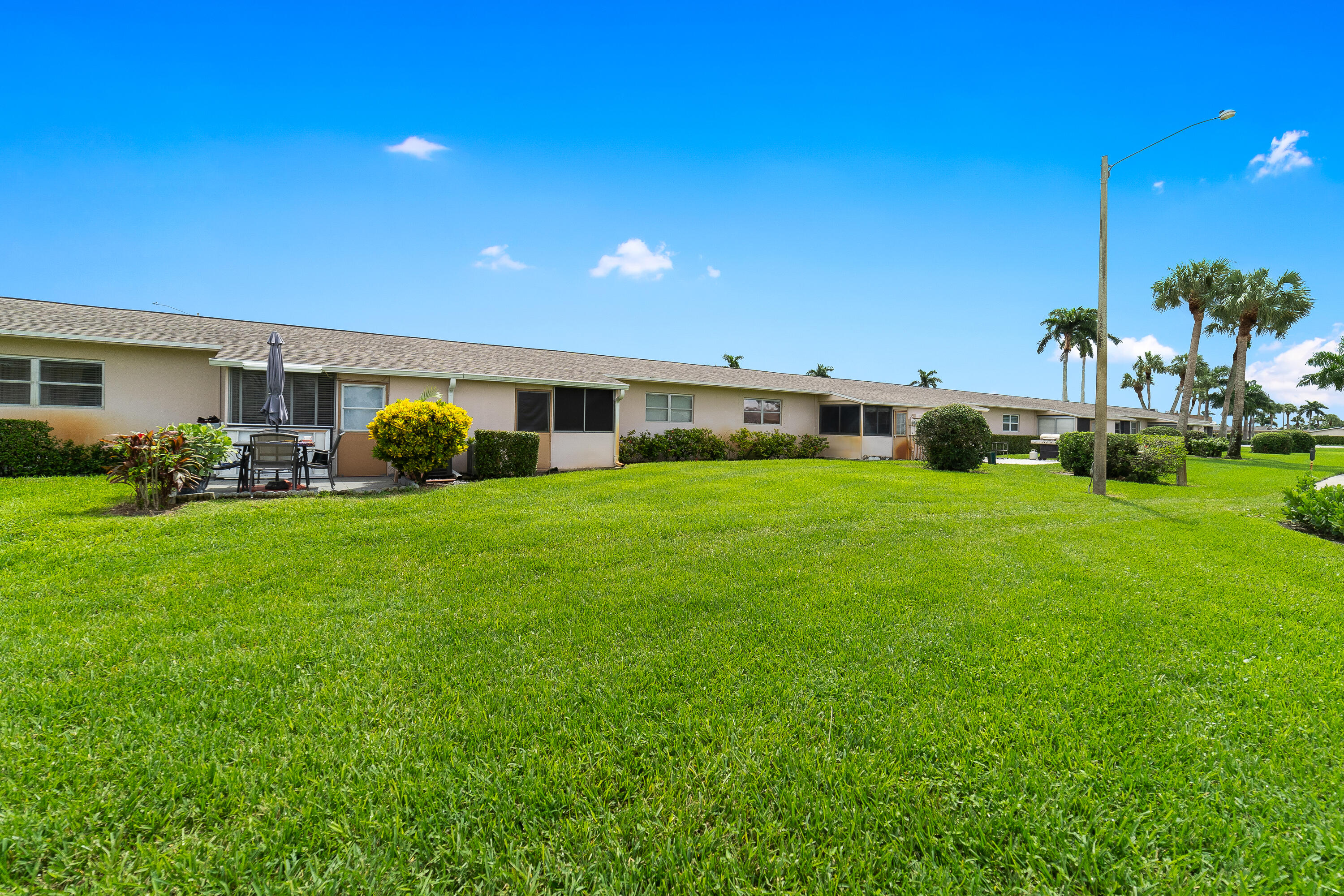 2567 Dudley Drive West, Unit F West Palm Beach, FL 33415 - Photo 34 of 41 a view of a house with a big yard and potted plants