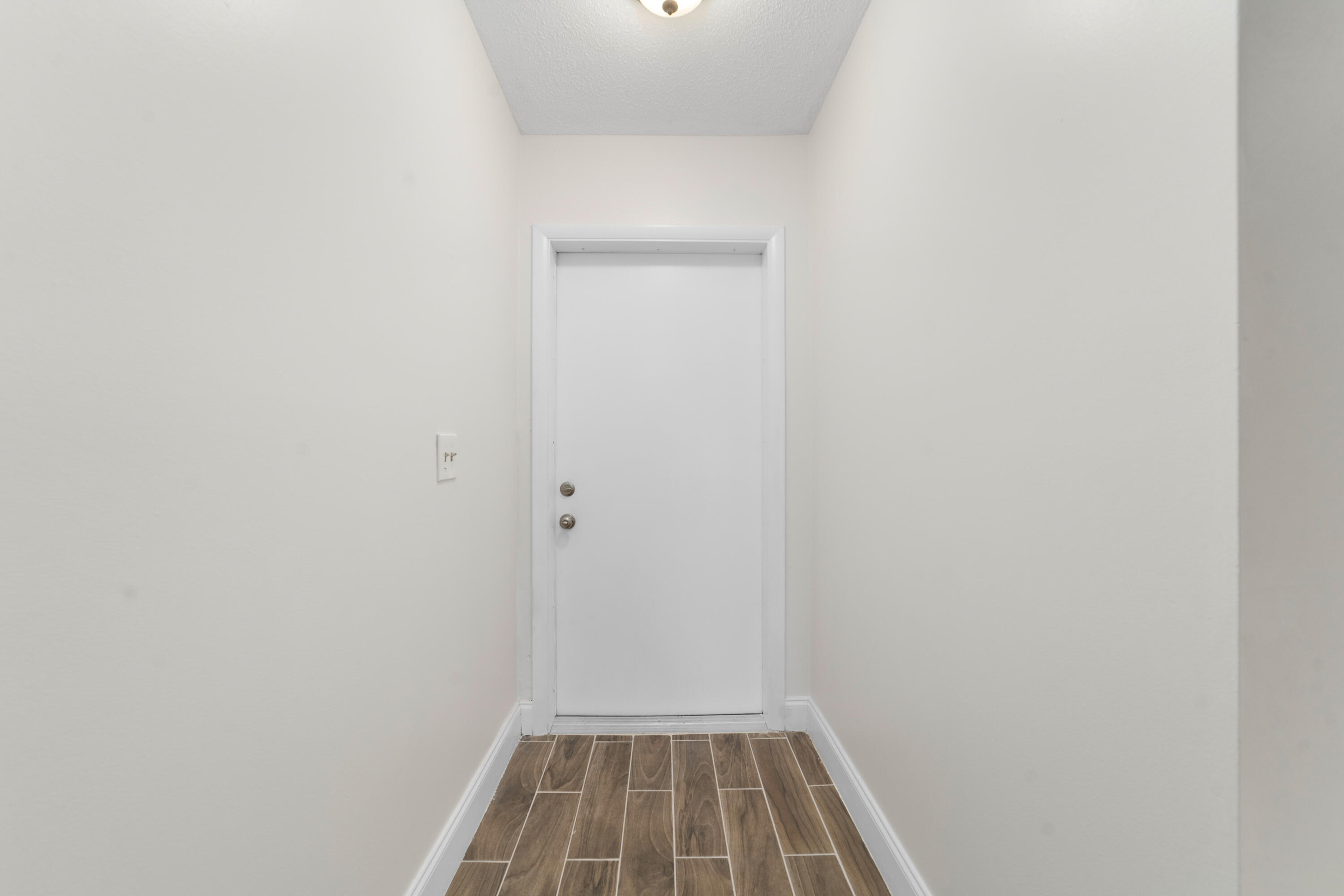 2567 Dudley Drive West, Unit F West Palm Beach, FL 33415 - Photo 4 of 41 a view of a room with wooden floor and white door
