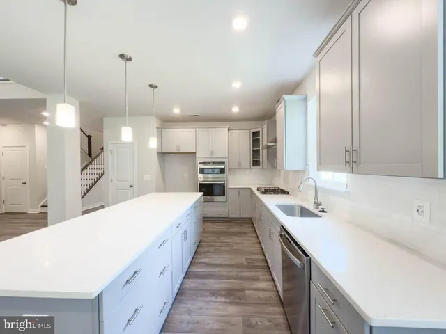 a large kitchen with a large counter top appliances and cabinets