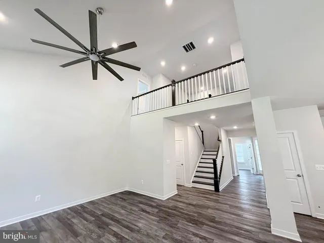 a view of a hallway with wooden floor and stairs