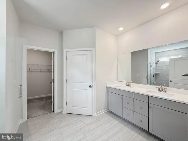 a spacious bathroom with a double vanity sink and mirror