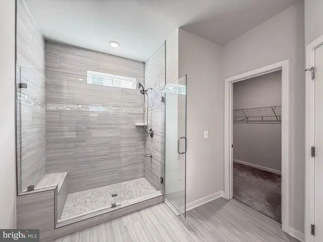 a bathroom with a glass door shower and a sink