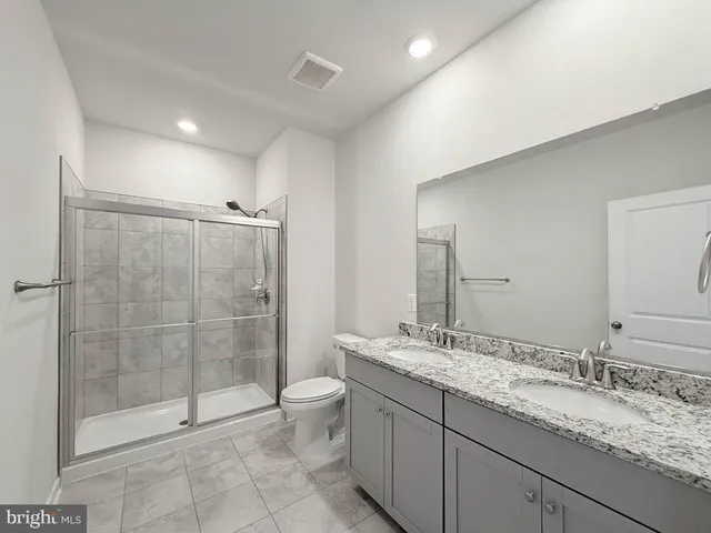 an empty room with chandelier fan and windows