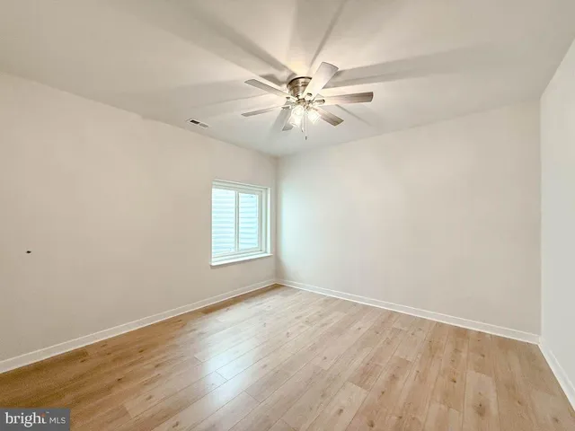 a view of a large room with wooden floor and iron stairs