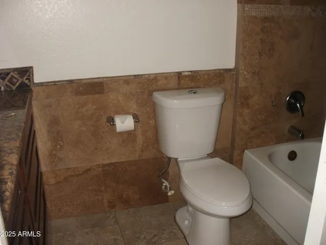 a white toilet sitting next to a bathroom sink