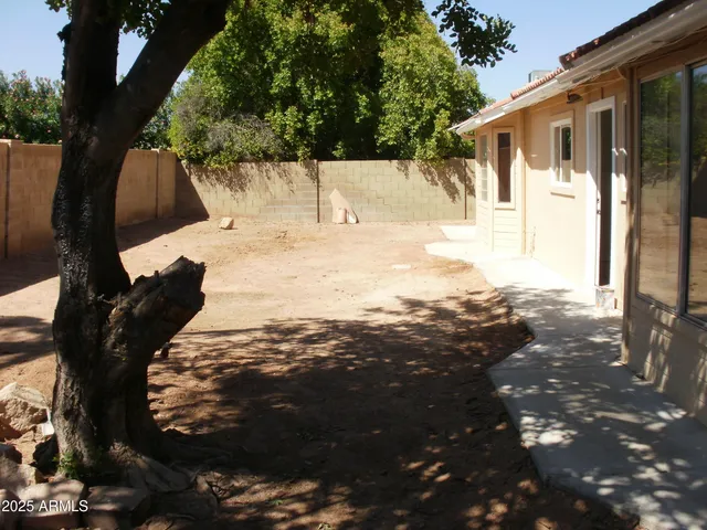 a view of a yard with wooden fence