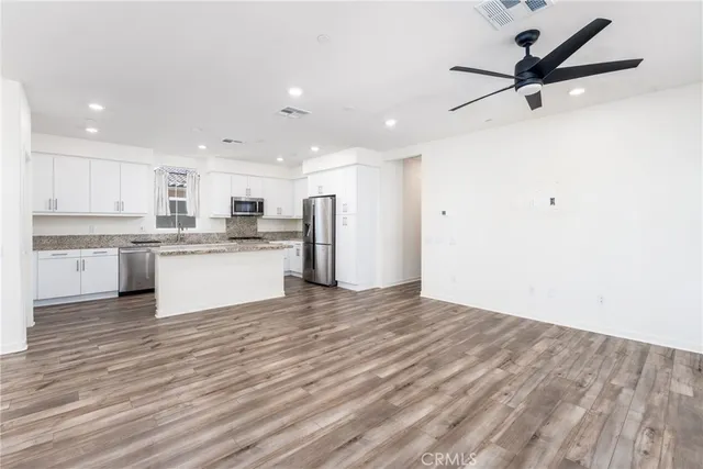 a view of kitchen with granite countertop cabinets and refrigerator
