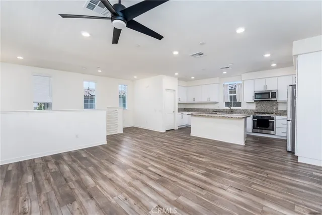 a kitchen with a refrigerator sink and cabinets
