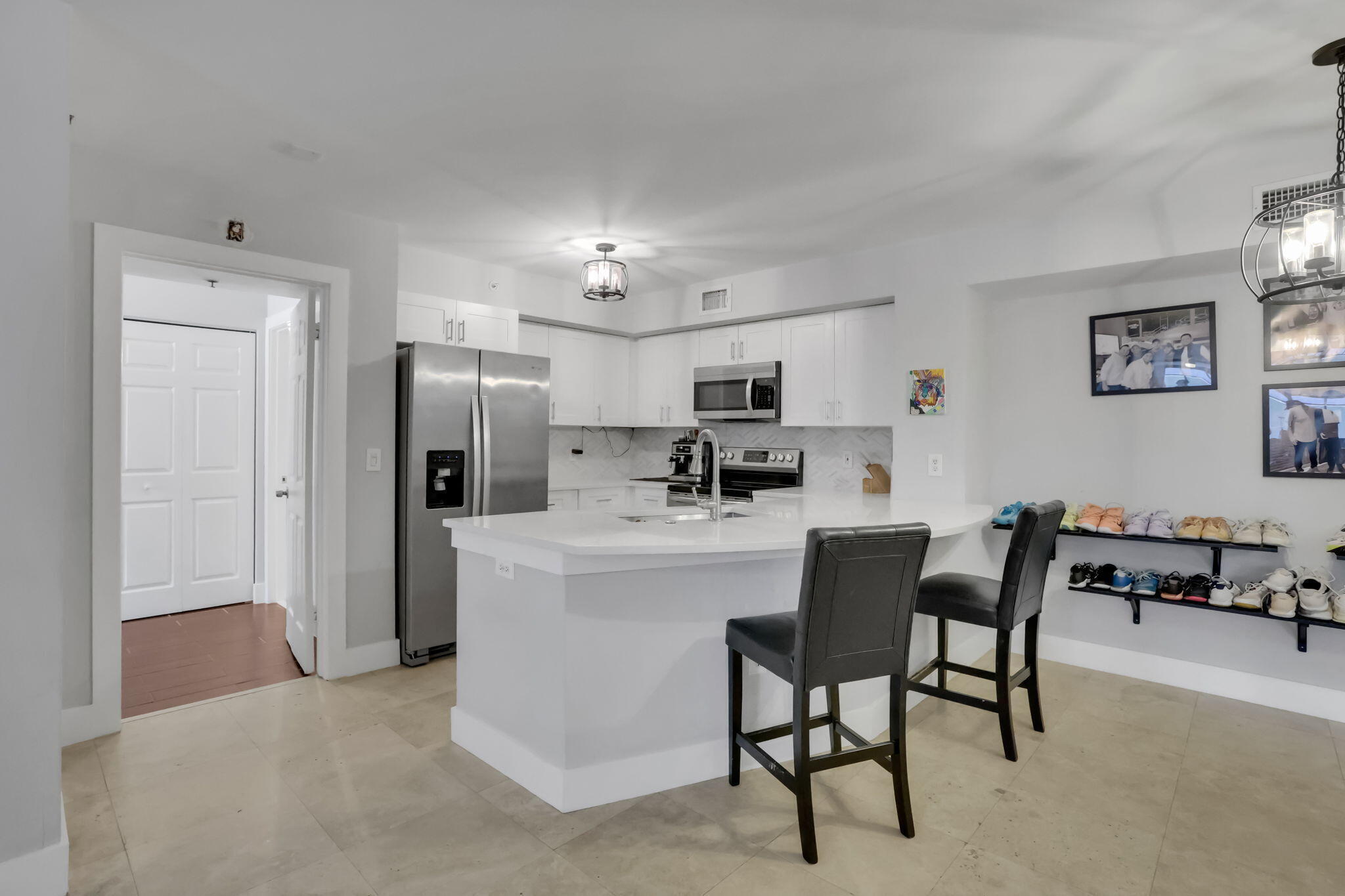 a kitchen with stainless steel appliances kitchen island a refrigerator and a dining table