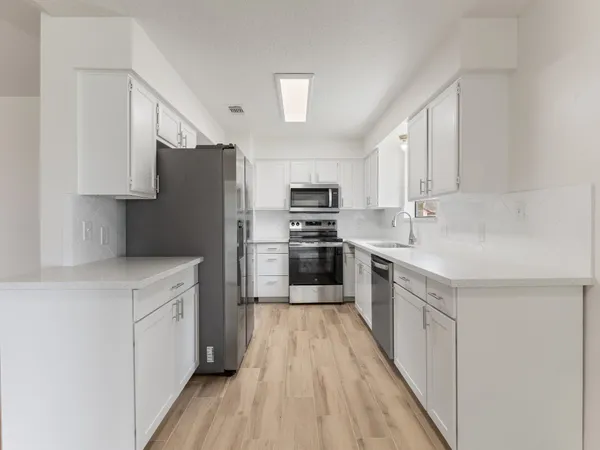 a kitchen with stainless steel appliances a refrigerator sink and microwave