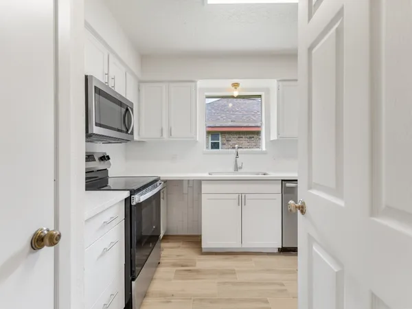 a view of a hallway with wooden floor