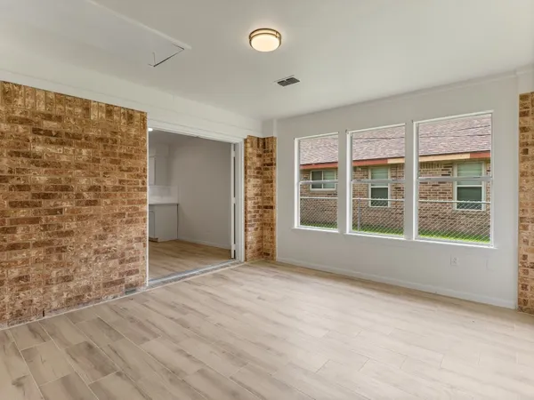 an empty room with wooden floor and ceiling fan