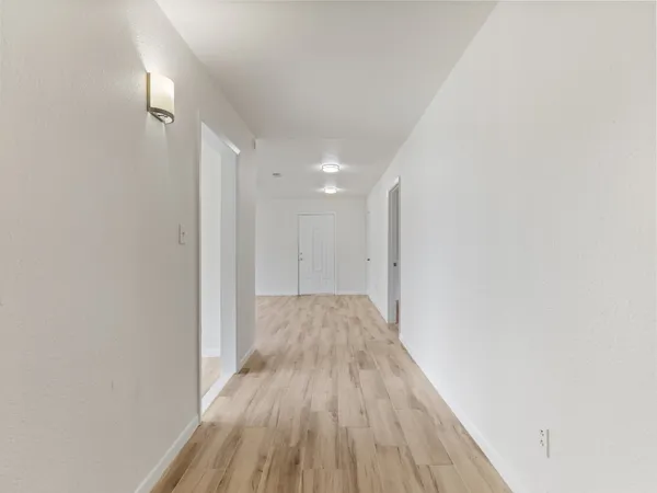 an empty room with wooden floor and window