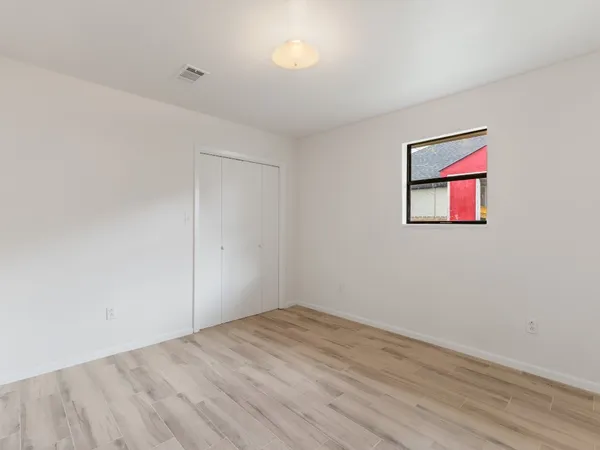 a view of an empty room with a chandelier fan