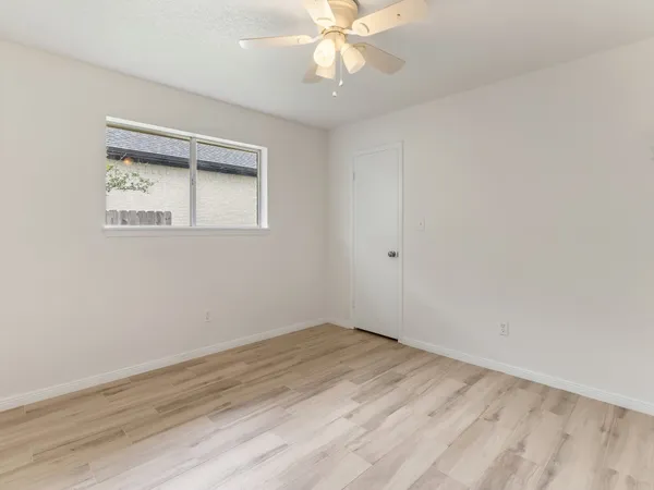 a view of an empty room with a window and a fan