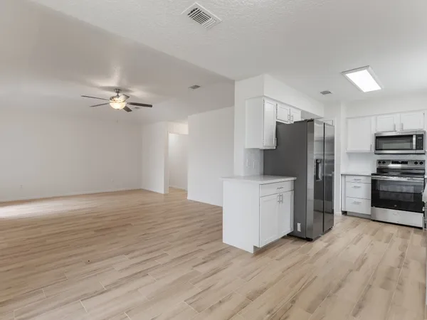 a kitchen with a refrigerator and a stove top oven