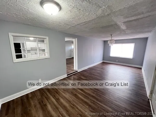 a view of a room with wooden floor and window