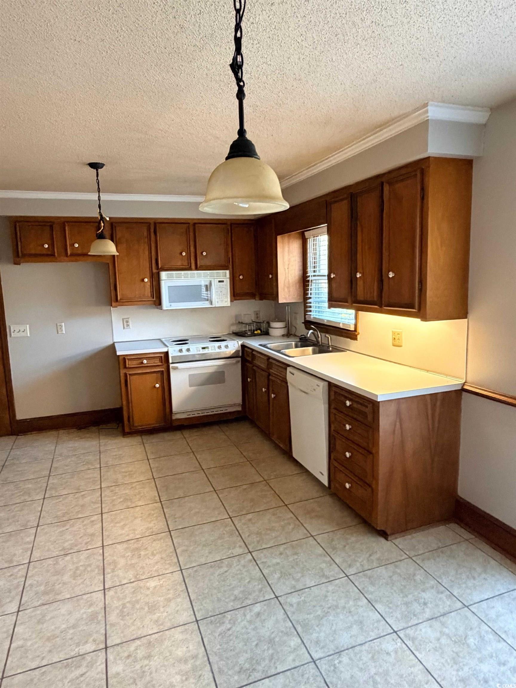 1320 Horseshoe Road Mullins, SC 29574 - Photo 4 of 22 Kitchen featuring decorative light fixtures, light countertops, white appliances, a textured ceiling, and light tile patterned floors