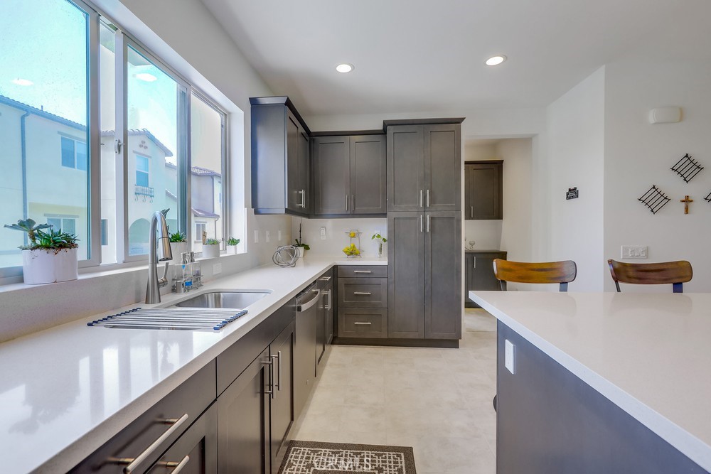 104 Alder Ridge Lake Forest, CA 92610 - Photo 17 of 74 a kitchen with a sink a counter top space cabinets and stainless steel appliances