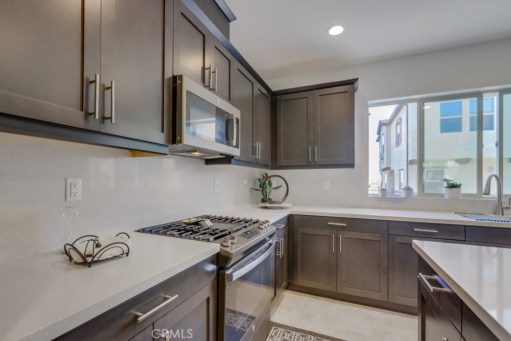 104 Alder Ridge Lake Forest, CA 92610 - Photo 19 of 74 a kitchen with stainless steel appliances granite countertop a sink stove and cabinets