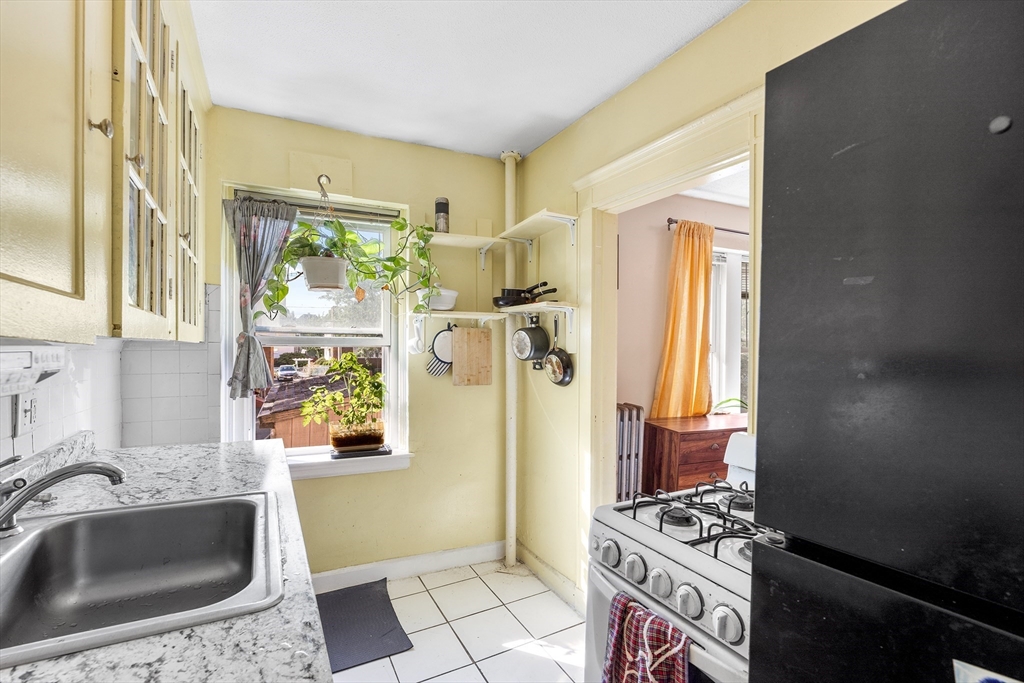 8 Walnut Street, Unit 5 Everett, MA 02149 - Photo 4 of 13 a kitchen with a sink a stove a refrigerator and a window