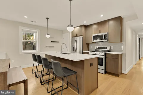 a kitchen with kitchen island white cabinets and stainless steel appliances