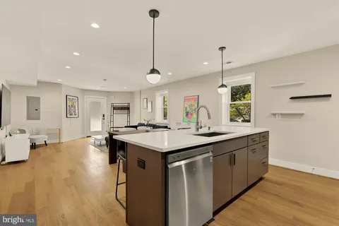a kitchen with kitchen island a sink stove and wooden floor